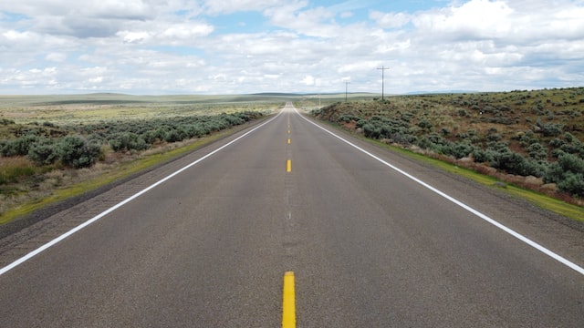 gray concrete road under blue sky