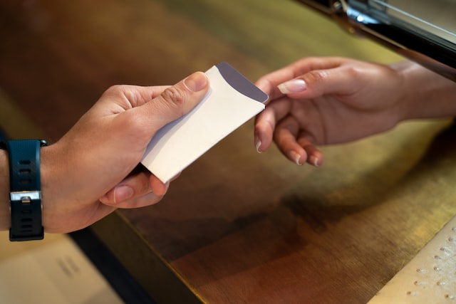 male guest giving keycard to a female receptionist