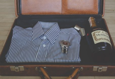 watch, whisky bottle and shirt in suitcase