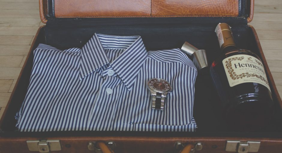watch, whisky bottle and shirt in suitcase
